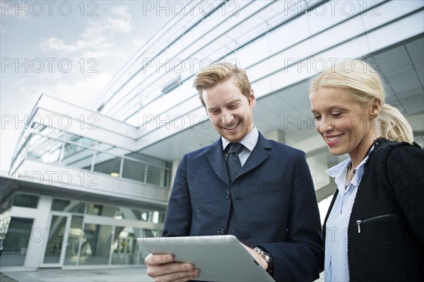 Business people using digital tablet outdoors