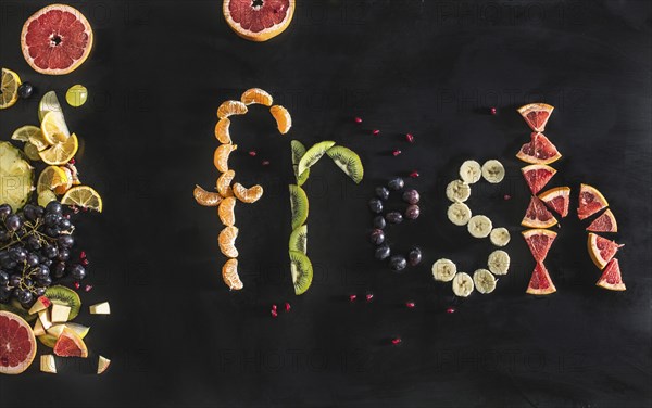 Close up of the word fresh written with sliced fruit