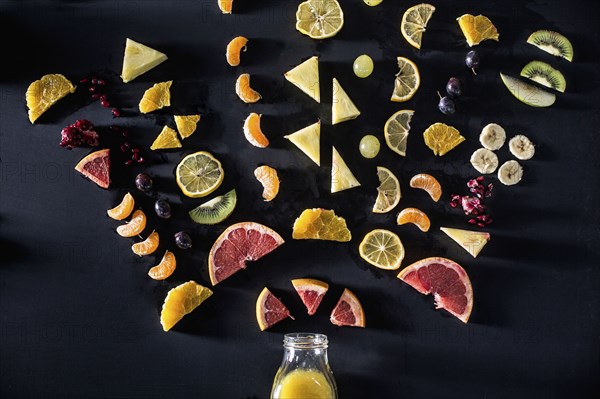 Sliced fruit arranged above juice bottle