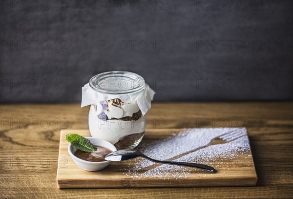 Chocolate parfait dessert with spoon and powdered sugar fork outline