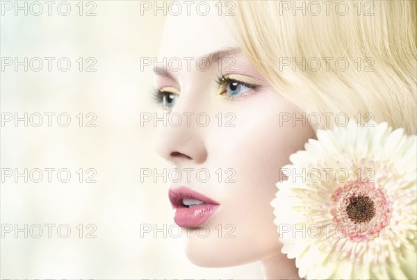 Caucasian woman with pink lipstick wearing white flower