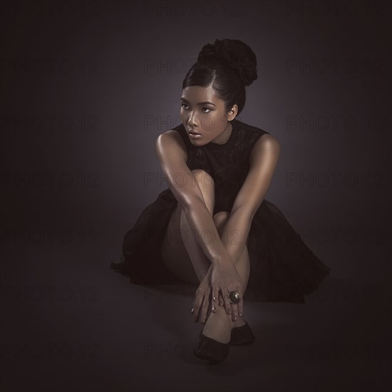 Glamorous woman sitting on floor