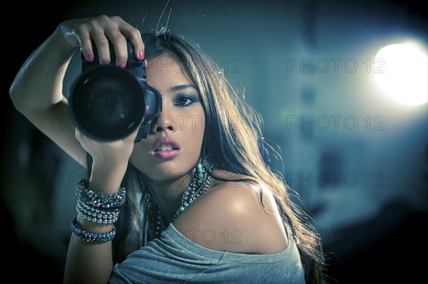 Glamorous woman photographer holding camera