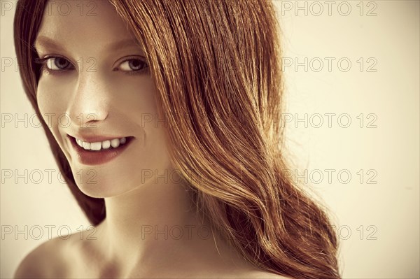 Close up of smiling woman with long red hair
