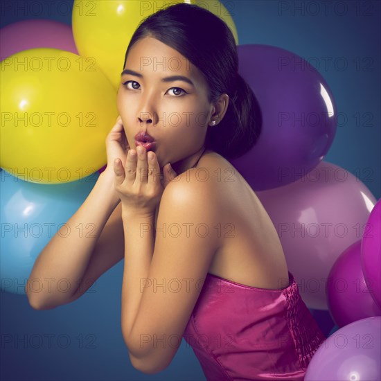 Woman blowing kiss with party balloons