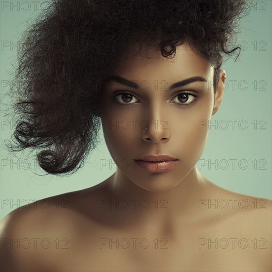 Close up of serious curly-haired woman