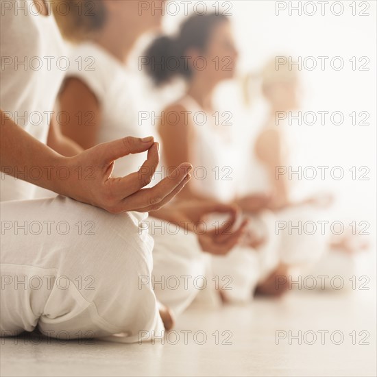 Close up of women meditating in yoga class