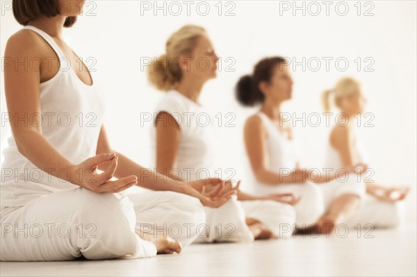 Close up of women meditating in yoga class