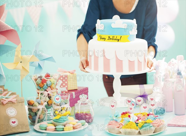 Woman holding birthday cake at party