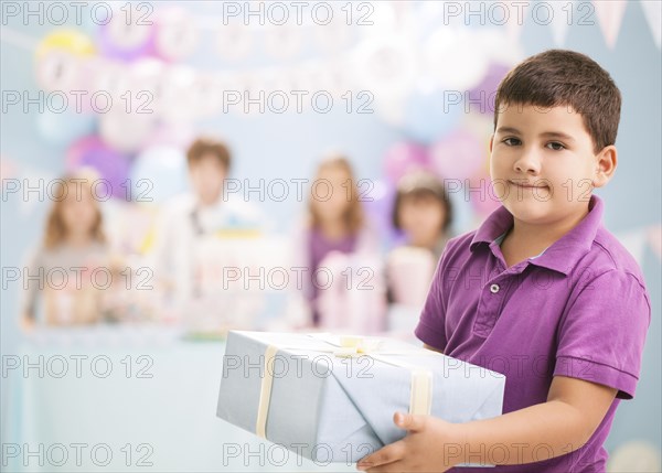 Boy holding wrapped gift at birthday party