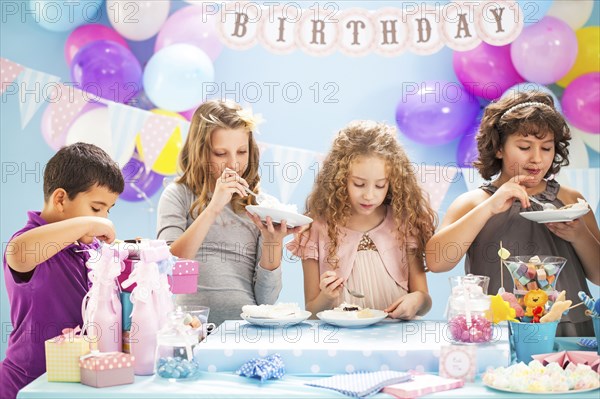 Children eating cake at birthday party