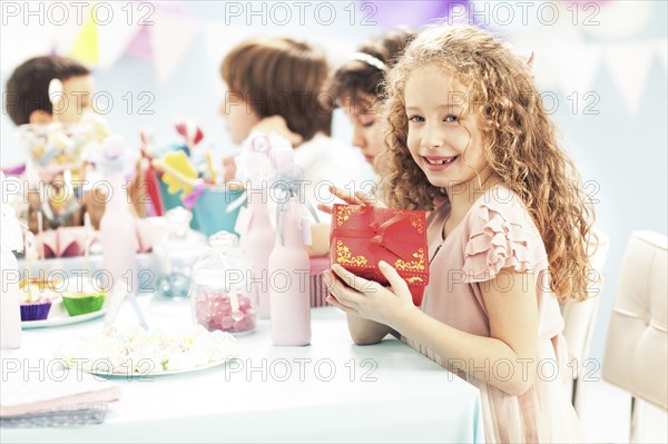 Girl holding wrapped gift at birthday party