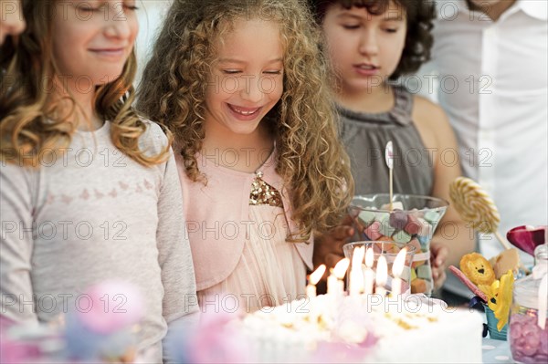 Girls looking at birthday cake at party