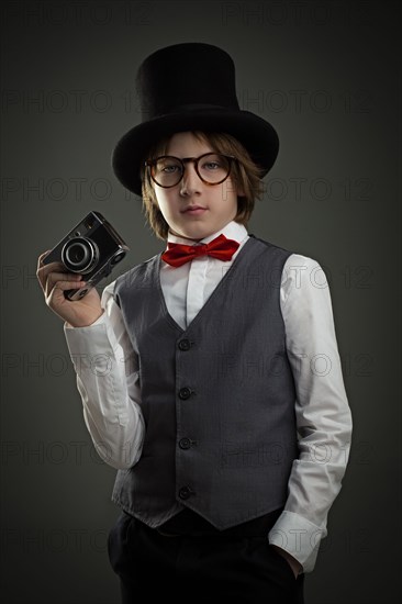 Boy in top hat photographing with vintage camera