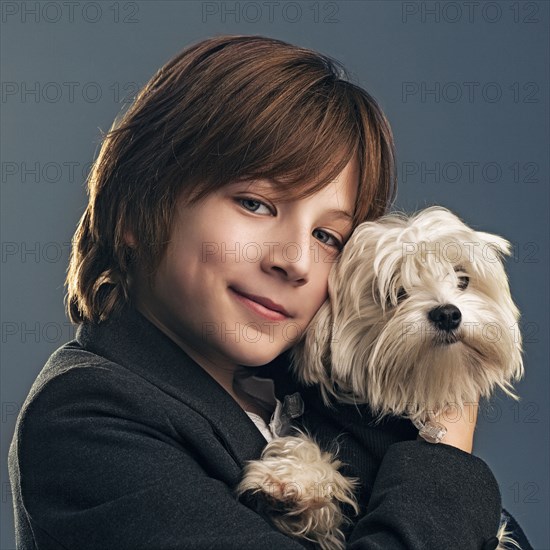 Close up of boy in suit holding dog