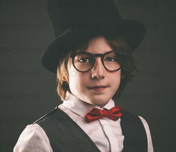 Close up of serious boy wearing top hat