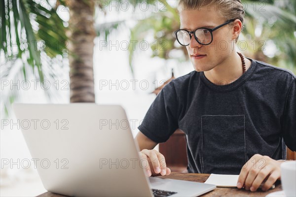 Caucasian man using laptop in cafe