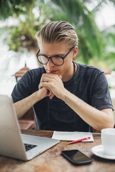 Caucasian man using laptop in cafe