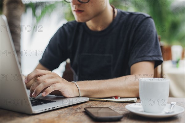 Caucasian man using laptop in cafe