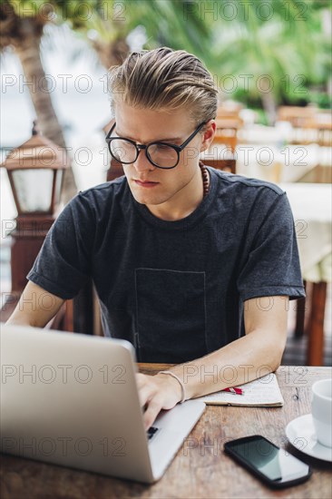 Caucasian man using laptop in cafe