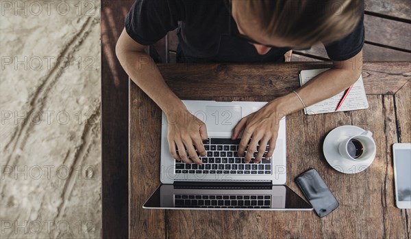 Caucasian man using laptop in cafe