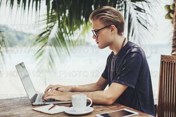 Caucasian man using laptop in cafe