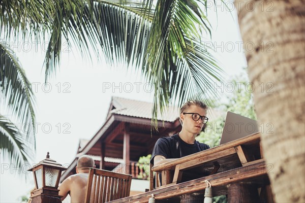 Caucasian man using laptop in cafe