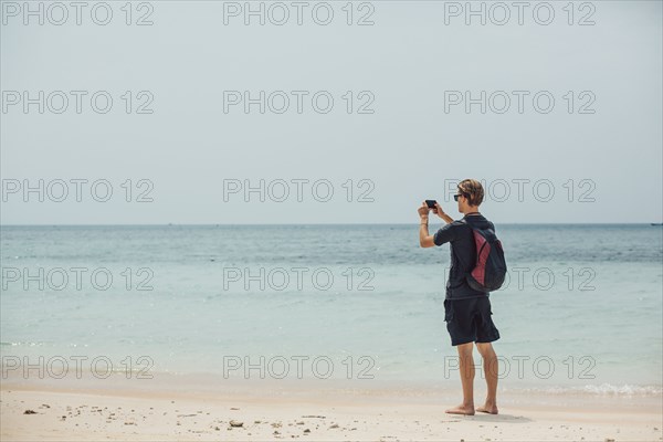 Caucasian man photographing seascape