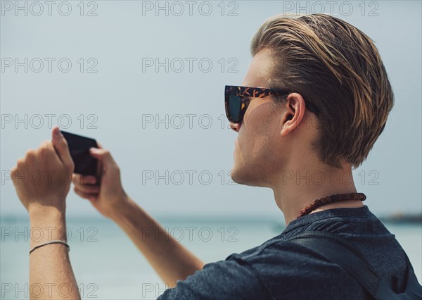 Caucasian man photographing seascape