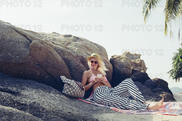 Caucasian woman sitting on beach