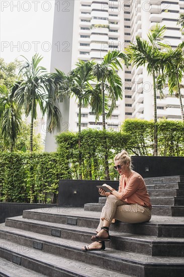 Caucasian woman using cell phone on stairs