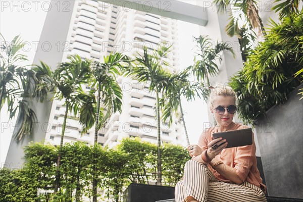 Caucasian woman using digital tablet on stairs