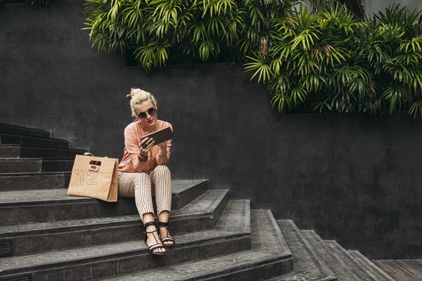 Caucasian woman using digital tablet on stairs