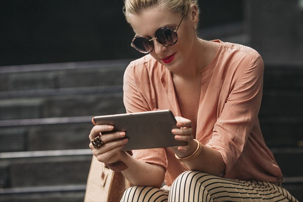 Caucasian woman using digital tablet on stairs