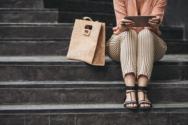 Caucasian woman using digital tablet on stairs