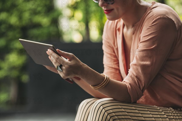 Caucasian woman using digital tablet outdoors