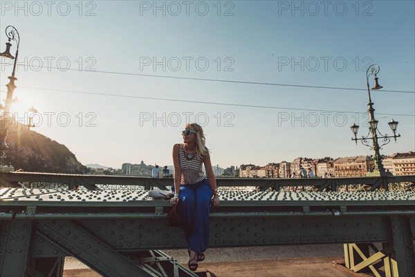 Caucasian woman sitting on bridge