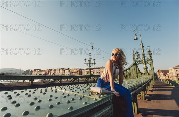 Caucasian woman sitting on bridge