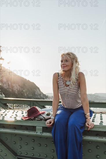 Caucasian woman sitting on bridge