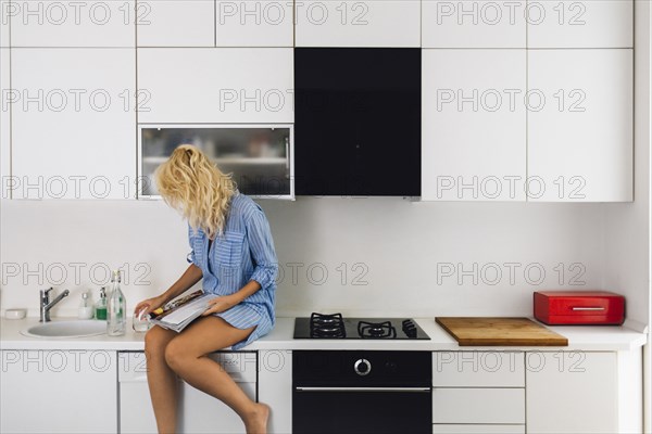 Woman reading on kitchen counter