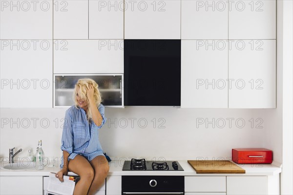 Woman sitting on kitchen counter