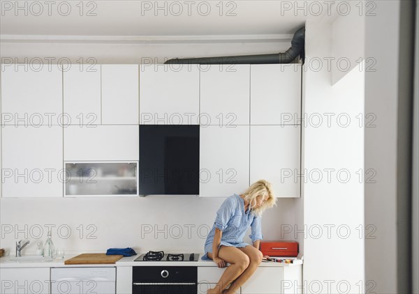 Woman reading on kitchen counter