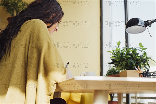 Caucasian woman writing at desk
