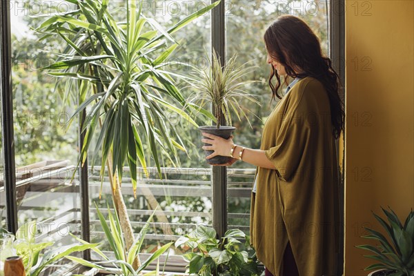 Caucasian woman holding potted plant