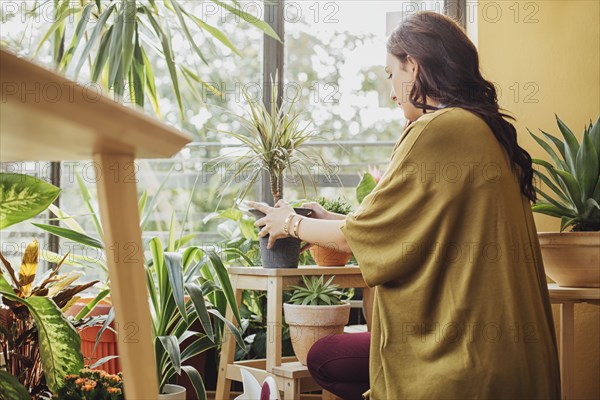 Caucasian woman holding potted plant