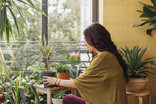 Caucasian woman holding potted plant