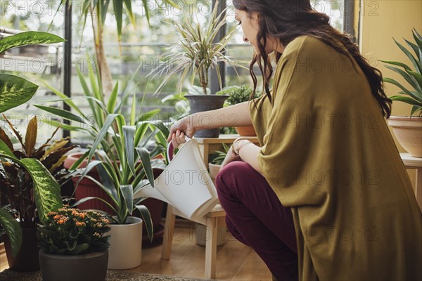 Caucasian woman watering potted plants