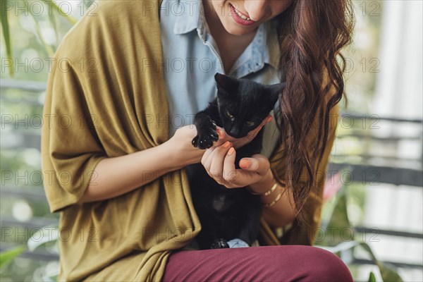 Caucasian woman holding kitten
