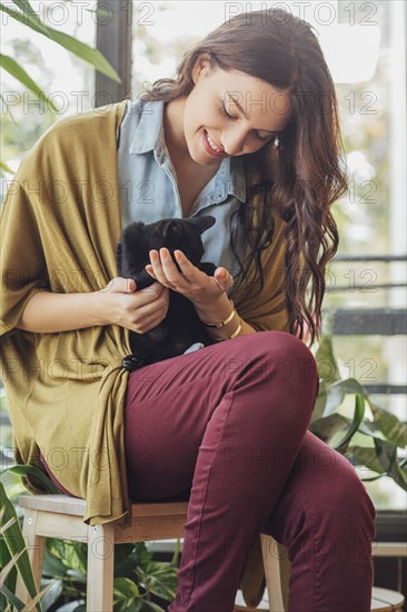 Caucasian woman holding kitten