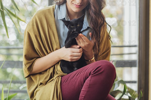 Caucasian woman holding kitten